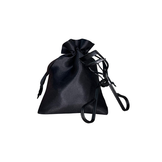 Pro Eyelash Curler with silicone pad and stainless steel design beside a black drawstring bag.