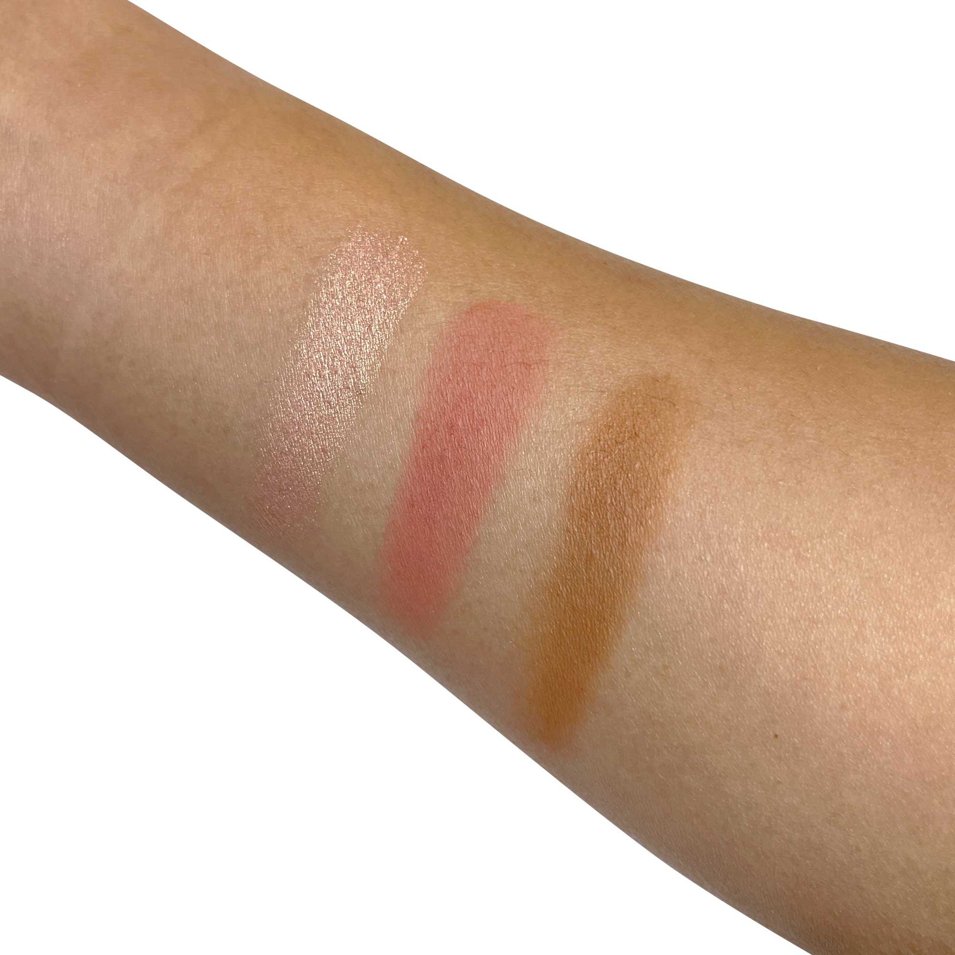 Pro Cheek Palette swatches on arm showcasing shimmering highlight, sun-kissed peach, and powdered brown shades.