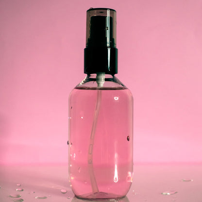 Oil Control Setting Spray in transparent bottle with black cap on pink background.